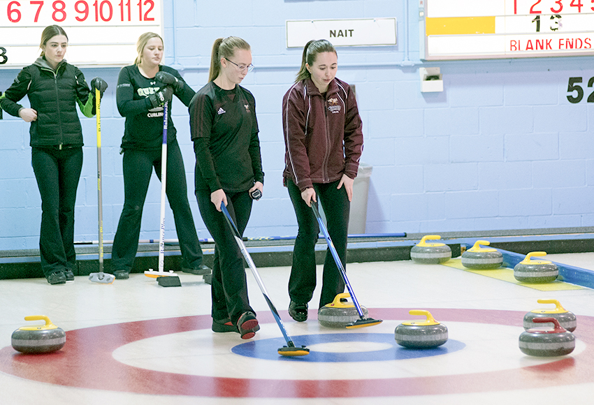 Griffins women's curlers Erin Wells, left, and Ashton Simard discuss strategy during a match against Red Deer College at the Winter Regional last month (Len Joudrey photo).
