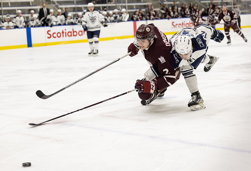 Hunter Donohoe gets taken down by an MRU defender in a race for the puck on Friday (Rebecca Chelmick photo).
