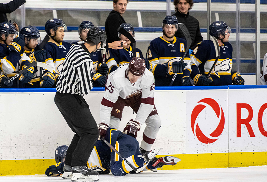 Conrad Mitchell dumps a UBC player in front of their bench on Saturday. The Griffins' plan to play physical worked for awhile against the speedy, skilled Thunderbirds before the wheels fell off in the third period (Derek Harback photo).