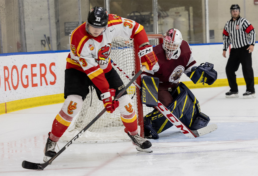 Calgary's Max Patterson, who scored twice on Friday, looks for an opening against MacEwan goaltender Eric Ward (Rebecca Chelmick photo).