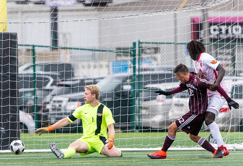 Joseph Abrahart chips it past Calgary Dinos goalkeeper Jake Ruschkowski in the 87th minute to deliver a 1-0 win for the Griffins on Sunday (Chris Piggott photo).