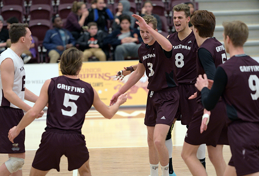 Jordan Peters trades high fives with setter Caleb Weiss while teammates gather around to celebrate a point on Friday. Peters ended the match with a thundering kill (Chris Piggott photo).