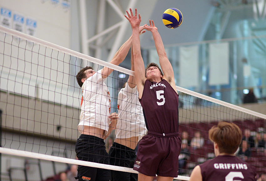 Caleb Weiss battles two Dinos for a ball at the net on Friday (Chris Piggott photo).
