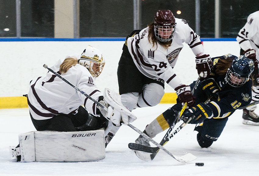 Jaime Erickson checks NAIT's Kendra Hanson in the nick of time in front of goaltender Sandy Heim during a game last month (Matthew Jacula photo).