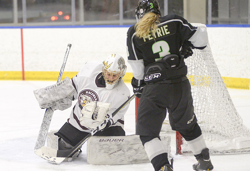 Sandy Heim makes a glove save - one of her 39 stops on the evening - with Red Deer College's Jade Petrie on the doorstep (Len Joudrey photo).