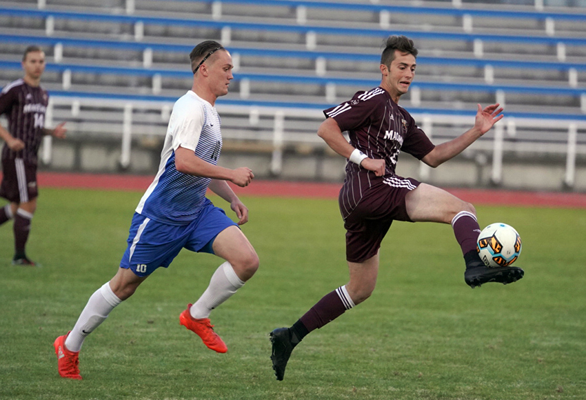 MacEwan's Sean Douglas handles a touch in front of Victoria's Michael Baart on Friday (Courtesy Victoria Vikes).