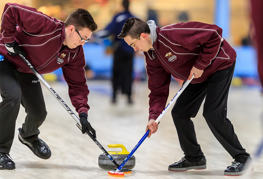 Men's team members Jordan Geiger, left, and Brandon Rubisch sweep a rock during last season's Winter Regional at the Avonair Curling Club (Robert Antoniuk photo).