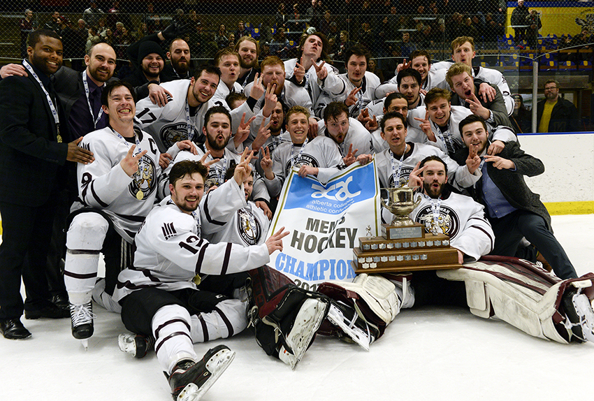 The MacEwan Griffins men's hockey team celebrates with the trophy and banner after winning their second-straight ACAC Championship on Sunday night at NAIT Arena (Len Joudrey photo).