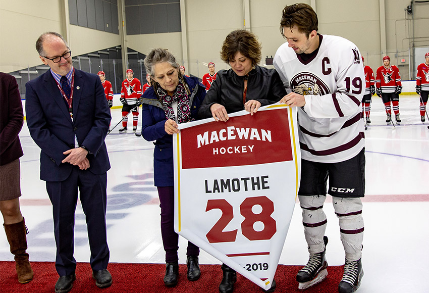 Griffins captain Cam Gotaas, right, presents a special banner to Nakehko Lamothe's mother and grandmother in a pre-game ceremony Saturday on the one-year anniversary of his passing (Joel Kingston photo).