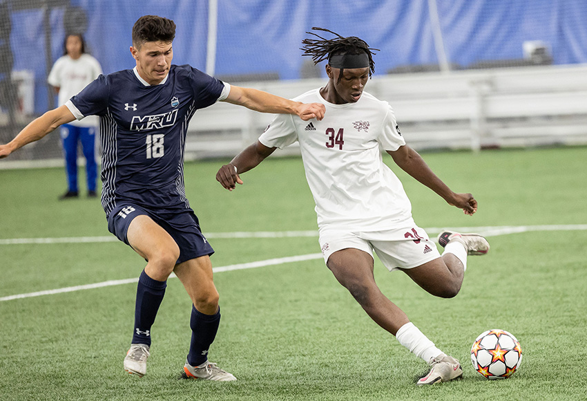 MacEwan defender Cedric Nataroume advances the ball out of the zone under the watchful eye of MRU’s Mowbray Beghin on Saturday (Rebecca Chelmick photo)