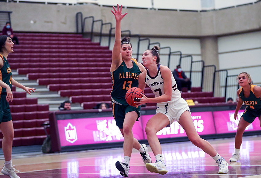 Mackenzie Farmer drives the lane against Alberta's Claire Signatovich on Wednesday. Farmer was the bright spot for MacEwan with a game-high 23 points (Eduardo Perez photo).
