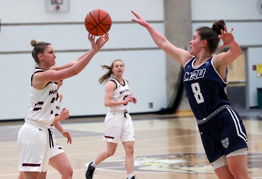 Hannah Gibb puts up a three-point attempt under pressure from MRU's Abbey Wilkinson on Friday night (Eduardo Perez photo).
