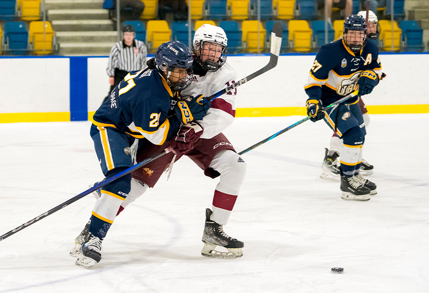 Tess Collier battles for a loose puck against UBC last weekend. She has been one of MacEwan's top blue liners this season (Bob Frid photo).