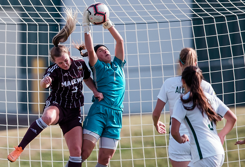 Meagan Lemoine battles in the air for a ball with Alberta keeper Ashley Turner on Saturday (Don Voaklander photo).