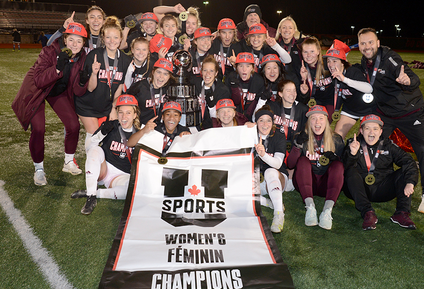 The Griffins pose with their national championship banner after beating Trinity Western on Sunday (Vaughn Merchant photo).
