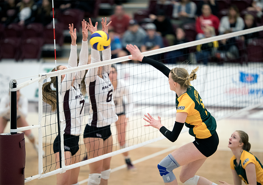 Kate Rozendaal and Haley Gilfillan post a block against Alberta on Saturday night. The Griffins came close to winning the rematch on Sunday but fell short in the fifth set (Robert Antoniuk photo).
