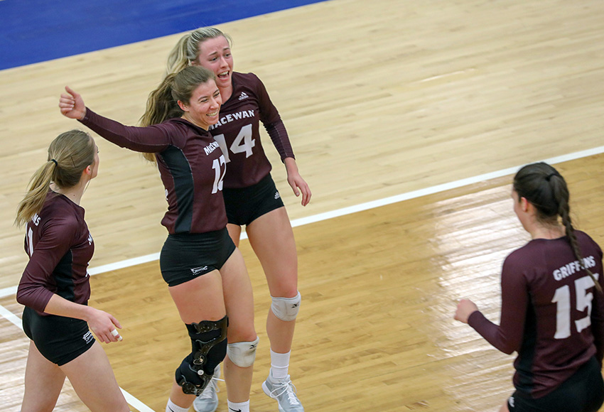 Kylie Schubert and Carly Weber embrace as they celebrate a point with teammates on Friday (Milana Paddock, Brandon University Athletics).