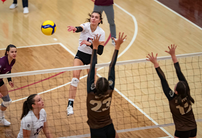 Mariah Bereziuk hits against the Manitoba Bisons block in a match last month. She enters a weekend series against cross-town rival Alberta sitting second in Canada West in kills/set (Eduardo Perez photo).