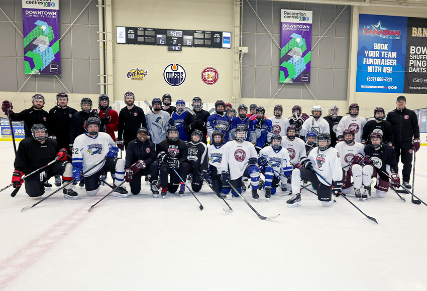 Griffins players and coaches pose with youth from Calling Lake and Wabasca after an on-ice session at the Downtown Community Arena on Thursday (Jefferson Hagen photo).